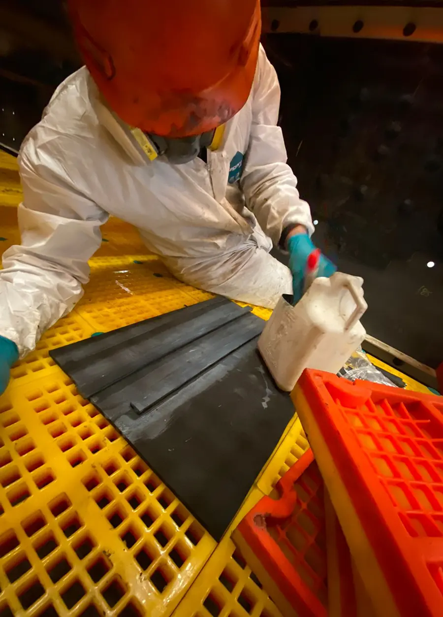 Un soldador con casco protector trabajando, produciendo chispas brillantes en un taller.
