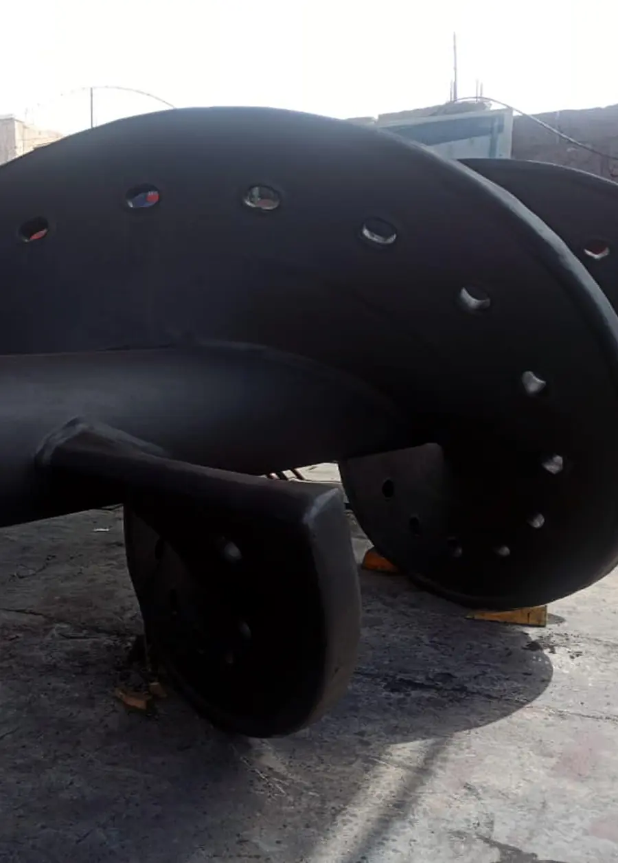 Primer plano de una tubería industrial gris con un revestimiento interior oscuro.